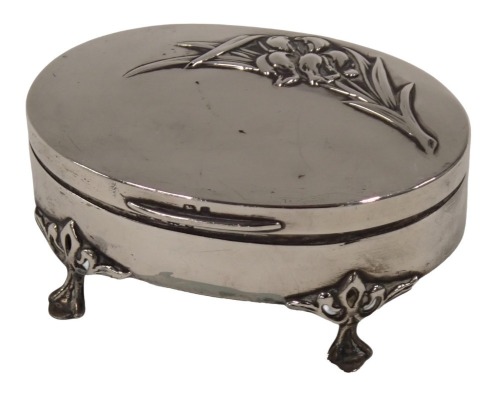 A George V silver trinket box, the oval top with lilies, on four claw feet, with a green baize lined interior, Birmingham 1929, 3.45oz.