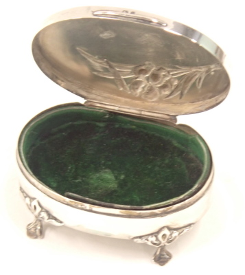 A George V silver trinket box, the oval top with lilies, on four claw feet, with a green baize lined interior, Birmingham 1929, 3.45oz. - 2