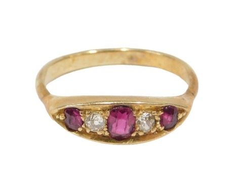 A ruby and diamond half hoop dress ring, set with three oval cut rubies, each claw set, and two tiny diamonds, on a yellow metal band unmarked, ring size T, 3.9g all in.