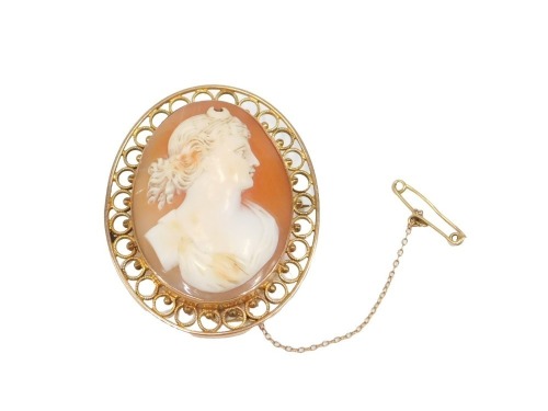 A shell cameo brooch, with maiden looking dexter, with half moon headdress, in a yellow metal pierced frame border, on single pin back with safety chain, unmarked, 4cm x 4.5cm, 11.8g all in.