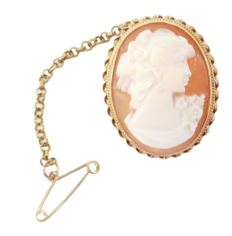 A 19thC shell cameo brooch, the oval shell cameo depicting maiden looking dexter, in rub over setting, with a rope twist border, on single pin back with safety chain, yellow metal stamped 9ct, 2.5cm x 1.5cm, 5.2g all in.