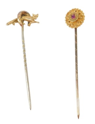 Two stick pins, comprising a horse's hoof and fox topped stick pin, unmarked, and a cluster set with central ruby and yellow metal, unmarked, 2.3g all in, both partially boxed. (2)