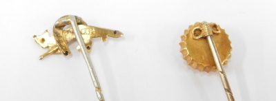 Two stick pins, comprising a horse's hoof and fox topped stick pin, unmarked, and a cluster set with central ruby and yellow metal, unmarked, 2.3g all in, both partially boxed. (2) - 3