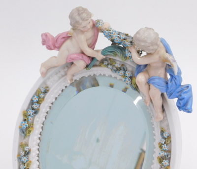 A Dresden porcelain table mirror, decorated with cherubs (AF), with a wooden easel back and Augustus Rex monogram, 30cm high. - 2