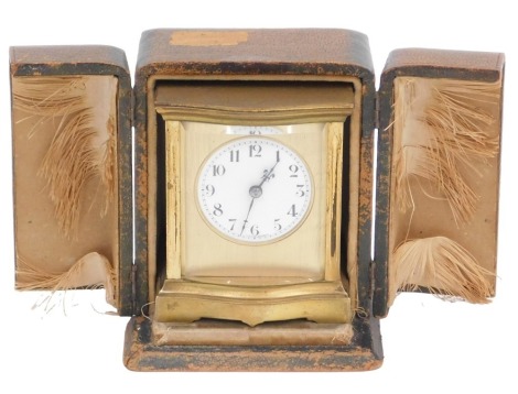 An early 20thC French brass carriage timepiece, with four bevelled glass plates, the dial with Arabic numerals, stamped Made in France, in a leather travelling case.