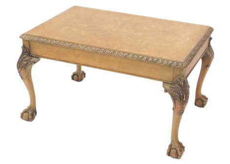 A walnut coffee table, the quarter veneer top with a carved edge, on carved cabriole legs with ball and claw feet, 43cm high, 75cm wide.