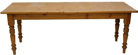 A varnished pine kitchen refectory table, rectangular top, on turned legs, 77cm high, the top 212cm x 82cm.