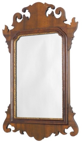 A walnut framed wall mirror, in George I style, with parcel gilt and moulded border, 57cm high, 35cm wide.