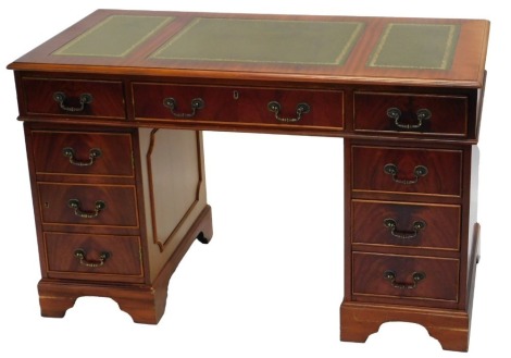 A mahogany pedestal desk, the rectangular top with three green leather inserts and a moulded edge, above an arrangement of nine drawers, 122cm wide.