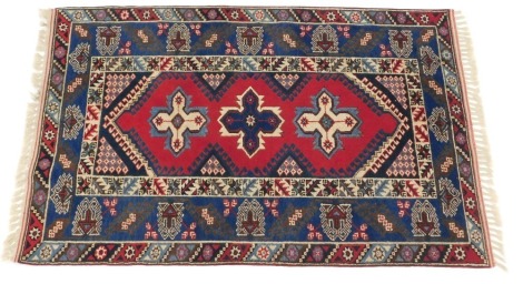 A Turkish carpet, with a design of medallions, on a red ground, with geometric spandrels, one wide, two narrow borders, 206cm x 168cm.