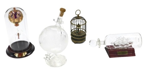 Miscellaneous trinkets, comprising a miniature globe decanter, USS Constitution glass ship in a bottle, glass hot air balloon in bottle, and a bird automation. (4)