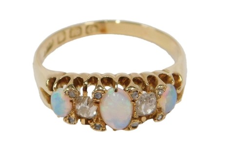 An 18ct gold late 19th/early 20thC opal and diamond half hoop dress ring, set with three cabochon cut opals and ten old mine cut diamonds, the two largest diamonds 3.3mm x 2.8mm x 2.2mm, approx 0.14ct each, claw set, on a plain band, Birmingham maker BS, 