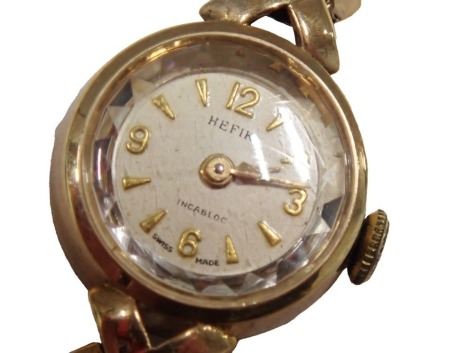 A 9ct gold Hefix lady's wristwatch, with a small silvered numeric dial, and V link bracelet, the dial 1.5cm diameter, 18.5g all in.