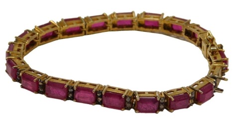 A tennis bracelet, set with ruby and garnets, in a gold finish setting, stamped 925, one stone loose, 18cm long, 19.5g all in.