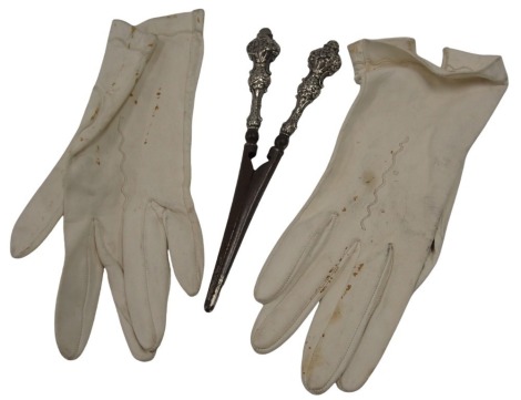 A pair of Edward VII silver handled glove stretchers, with stainless steel blades, the handles of embossed design, Birmingham 1902, together with a pair of gloves.