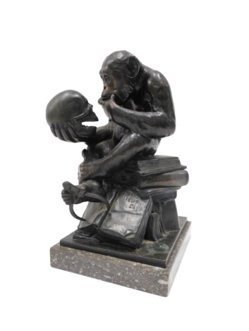 20thC School. Figure of a monkey holding a skull, whilst seated on various books, relating to Darwin's theory, bronze on a rectangular marble base, 33cm high.