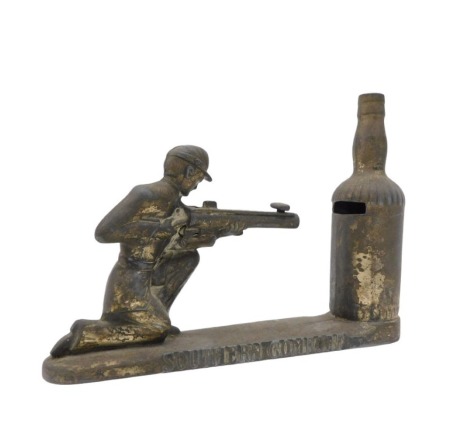 A cast metal money box, titled Southern Comfort, modelled in the form of a gentleman firing a rifle into a bottle, 26cm long,