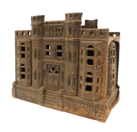 A painted cast iron money box, modelled in the form of a castle or country house, titled County Bank, registration number 180427, 14cm wide.