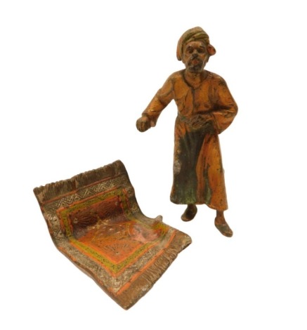 An Austrian cold painted metal figure, modelled in the form of an Arab standing on an Oriental carpet, 10cm high. (AF)