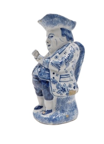 A 19thC Delft blue and white Toby jug, in seated position, unmarked, 26cm high. (AF)