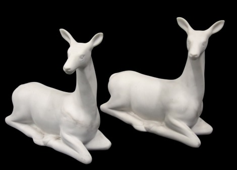 A pair of cream painted resin seated deer, 39cm long.