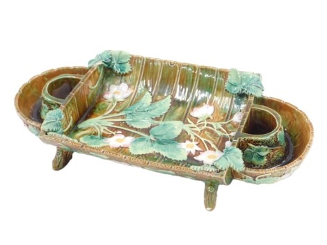 A 19thC Majolica strawberry dish or stand, decorated with strawberry plant flowers and leaves, on a stylised wooden ground, various marks to underside to include number 3423, possible crescent mark for George Jones, etc., 38cm wide.