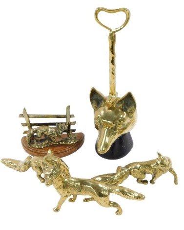 A brass door stop, modelled in the form of a foxes head, on ebonised base, a letter rack, modelled with a brass fox, and three solid brass foxes.