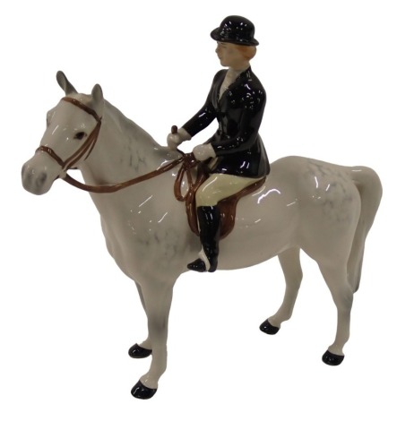 A Beswick ceramic model of a female huntswoman, seated on a grey horse, 21cm high.