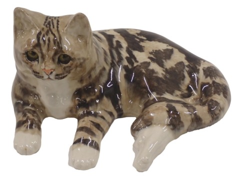 A Winstanley studio pottery recumbent tabby cat, signed to underside, 34cm wide.