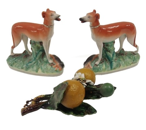 A pair of 19thC Staffordshire flatback greyhounds, 18cm high, AF, and a Majolica wall plaque of oranges and leaves, 25cm long.