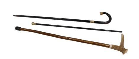 Three various walking sticks, comprising a horn handled turned wooden stick, 80cm long, a silver plated topped swagger stick, 74cm high, an ebonised and brass capped walking stick, 90cm high. (3)