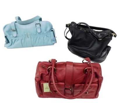 Three lady's handbags, comprising a Tommy and Kate red lady's handbag, a black leatherette lady's handbag, and a blue finish lady's handbag. (3)