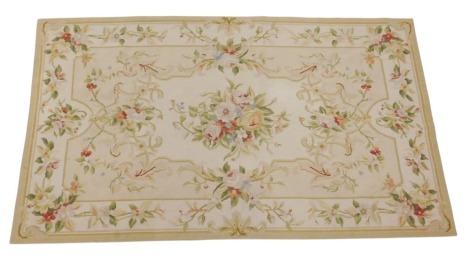 An Aubusson needlework rug, decorated with flower sprays, within a beige border, 150cm x 80cm.