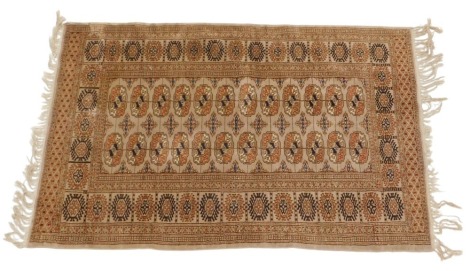 An Afghan rug, with a design of two rows of medallions, on a beige ground, one wide, four narrow borders, 153cm x 96cm.