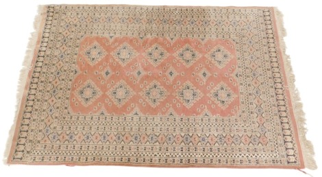 An Afghan style rug, with a design of lozenges on a coral coloured ground, one wide, six narrow borders, 202cm x 131cm.