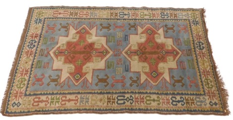 A Turkish rug, with a design of multicoloured star shaped medallions, on a blue ground, and one wide, two narrow borders, 242cm x 150cm.