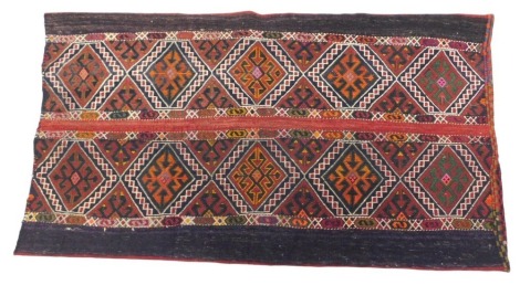 A Persian cushion case or bag, the top with a design of coloured medallions, flanked by plain aubergine coloured borders, with striped backing, 122cm x 90cm.