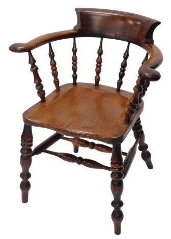 A 19thC yew and elm captain's chair, with spindle turned supports, solid seat, on turned legs, with H stretcher.