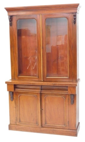 A Victorian mahogany bookcase, the top with a moulded cornice above two glazed doors, the base with two frieze doors, and two panelled doors, on a plinth, 207cm high, 124cm wide.