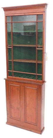 A 19thC pitch pine corner cabinet, with a glazed door above a panelled door on a plinth, 236cm high, 83cm wide.