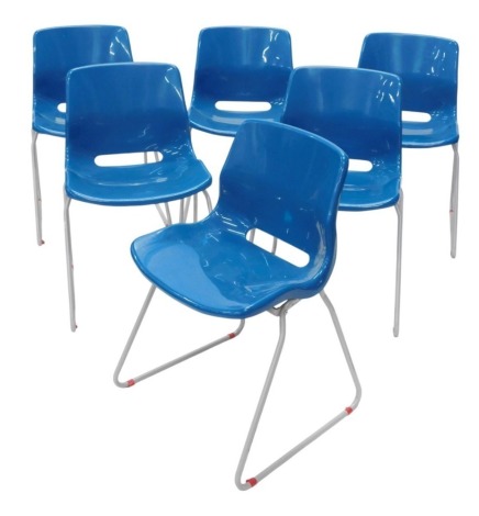 A set of six blue moulded plastic and tubular metal stacking chairs.