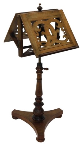 An early Victorian walnut duet stand, with two adjustable music stand sides, receptacles for candle arms, on a turned column, triform base, and bun feet, adapted, 110cm high.