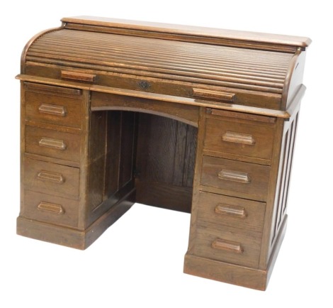 A Lebus oak roll top desk, with an arrangement of nine drawers on a plinth, 121cm wide.