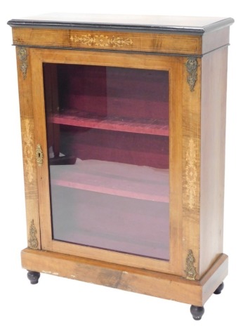 A late Victorian walnut and ebonised display cabinet, with an inlaid frieze and a glazed door, flanked by gilt metal mounts, on ebonised bun feet, 105cm high, 76cm wide.