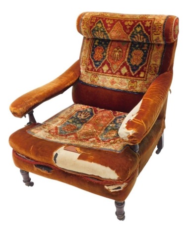 A late Victorian open armchair, with velvet and turkeywork upholstered back and seat, on turned legs, with castors. (AF)