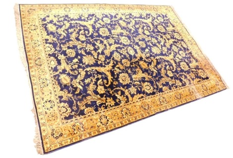 A large machine woven carpet, decorated with flowers, leaves, etc., in gold on a blue ground, one wide, two narrow borders, 356cm x 250cm.