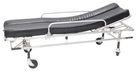 A tubular metal ambulance or hospital bed, with black leatherette padded seat, bearing serial number, on castors, 184cm long, 49cm wide. The upholstery in this lot does not comply with the 1988 (Fire & Fire Furnishing) Regulations, unless sold to a known