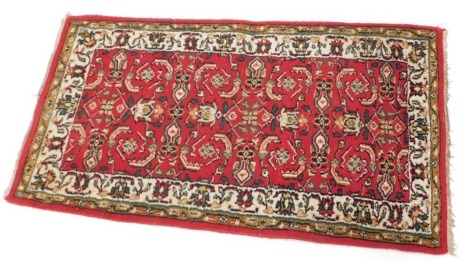 An Indian rug, with a central medallion, on a red ground, with cream spandrels, one wide, two narrow borders, 164cm x 94cm, and another similar, 144cm x 79cm. (2)