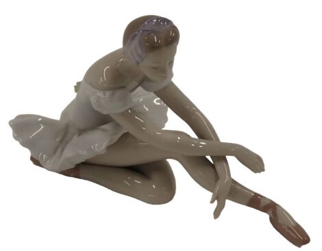 A Lladro porcelain figure of a seated ballet dancer, 14cm high.