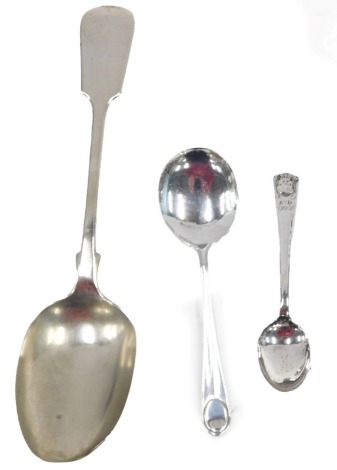 Two silver teaspoons, comprising fiddle pattern spoon and a George VI crested spoon, 0.88oz, and a silver plated serving spoon. (3)